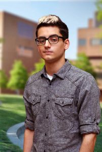 A three quarter portrait of Arman on the Library green.