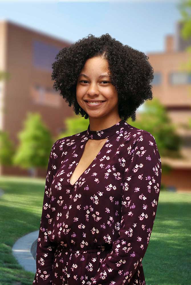 A three quarter portrait of Cierra on the Library green.