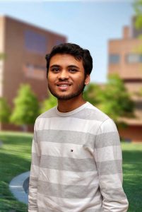 A three quarter portrait of Dhruvil on the Library green.