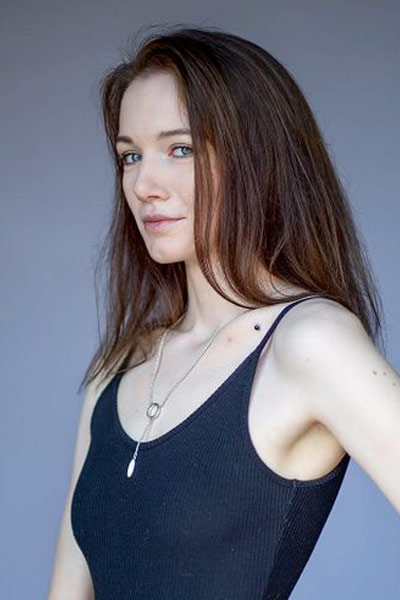 A three quarter portrait of young woman in a photographers studio