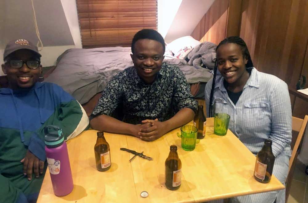 UMBC's two Rhodes Scholars casually sitting around a table smiling at the camera