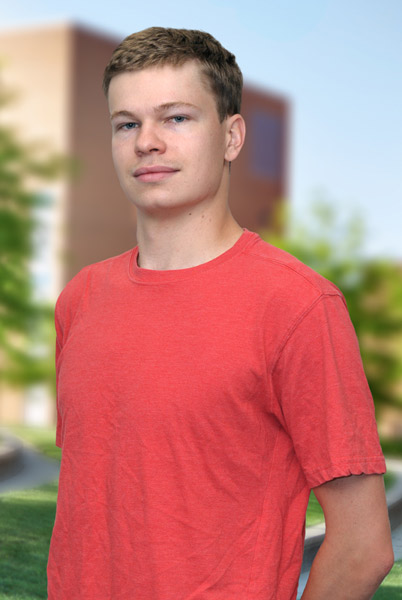 A three quarter informal portrait of a young man outside under a tree