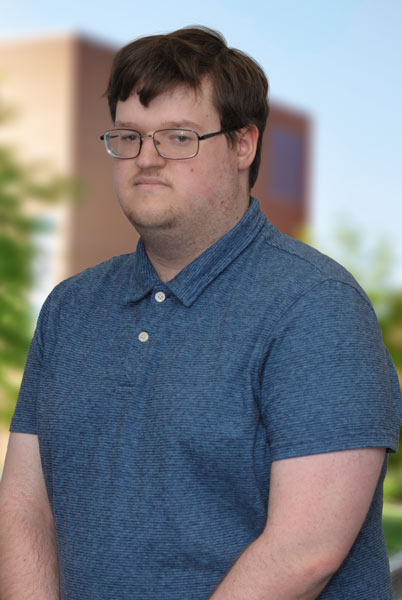 A three quarters portrait of a young man outside on campus