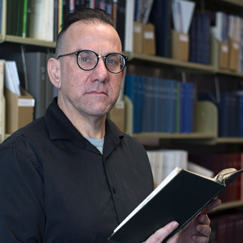 A reacher looking up from a book in a library